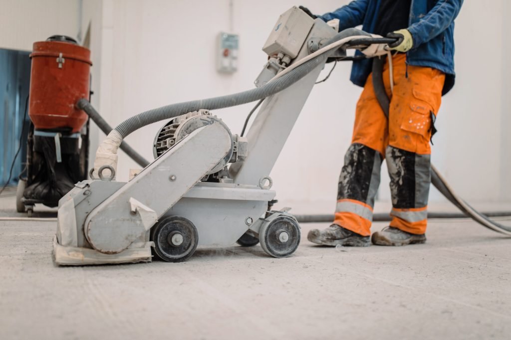 workers grind the concrete floor at the constructi 2022 11 29 00 02 47 utc scaled 1